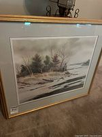 Framed lithograph print featuring a winter landscape with trees and a body of water, signed by Larry M Sherman.