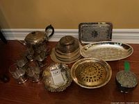 Full view of the silver plate and glass items including the teapot, mugs, dishes, and tray.