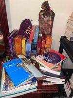 Photo of tarot and oracle card decks, storage pouches, and many spiritual books on small table