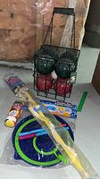 Sportcraft bocce ball set in metal carrier alongside large bubble wand and bubble mix bottle with juggling balls in the foreground.
