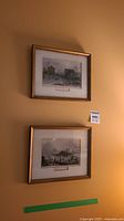 Two vintage Toronto prints hanging on a wall. The top print depicts the Fish Market, the bottom depicts the Harbour from 1844.