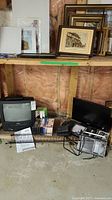 Photo showing overall lot including Symphonic 13 inch color TV with VCR, RCA 19 inch LED TV, radios, VHS tapes, CD stand and manuals.