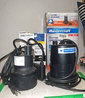 Photo showing both utility pumps with boxes behind them.