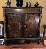 Front view of boulle style cabinet showing two doors and marble top