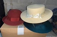 Photo showing three vintage Lady Stetson felt hats: rust cloche, cream wide-brim with bow and pearls, and dark green hat.