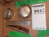 Photo showing four pieces in the vintage vanity set, including the engraved silver folding comb, keepsake boxes, and clam shell powder case.