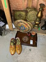 Wide view showing all main items in the lot: large wooden clogs, multiple decorative wooden trays, brass candle holder, ceramic pots, and a dark wood tray.