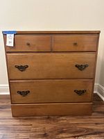 Front view of three-drawer Valley Forge by Baumritter dresser showing hardware and wood finish