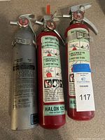Front view of three fire extinguishers showing gauges and handles