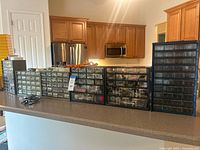 Row of five parts cabinets on counter showing clear drawers filled with hardware