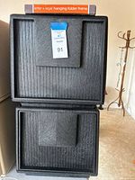 Front view of two stacked dark gray plastic drawer units with package of file rails on top