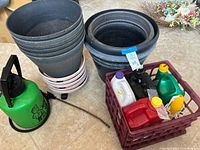 Group view of stacked plastic pots, rolling caddies, green Spray Doc sprayer and crate holding chemical jugs
