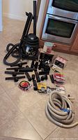 Full lot view showing vacuum, hoses, attachments, packaged accessories