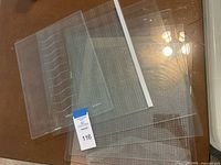 Stack of six tempered glass refrigerator shelves on table