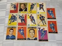 Front view of vintage Toronto Maple Leafs hockey cards laid out showing players and coach, colorful vintage card fronts with team logos and player images.