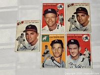 Five 1954 Topps baseball cards on display including Joe Collins, Johnny Antonelli, Marion Fricano, and Charlie Silvera in mixed condition visible wear on edges and corners.