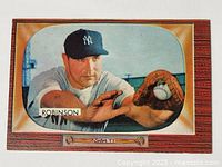 Photo showing the 1955 Bowman Eddie Robinson NY Yankees baseball card with woodgrain border and color image of player catching ball.