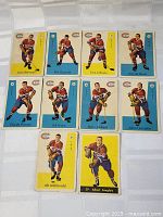 Top view showing eleven vintage Parkhurst Montreal Canadiens hockey cards laid out on a flat surface. Cards show players in Canadiens uniforms with yellow and blue backgrounds.