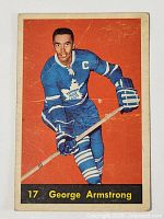 Front of vintage 1960-61 Parkhurst hockey card showing George Armstrong in Toronto Maple Leafs uniform, holding hockey stick with orange background.