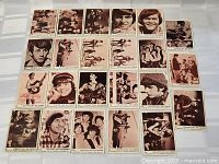 Photo shows 22 The Monkees trading cards laid out in rows on a flat surface, featuring black and white or sepia tone images of the band members individually and in groups with text indicating 'Collect all 44 cards'.