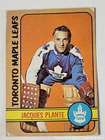 Front side of 1972-73 O-Pee-Chee Jacques Plante hockey card featuring portrait of player in Maple Leafs goalie uniform with orange background.