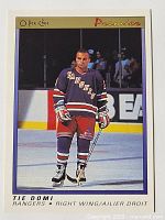 Front of 1990-91 OPC Premier Tie Domi rookie hockey card showing player in New York Rangers jersey on ice.