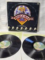 Double vinyl records and original album sleeve with visible signs of wear and tear but intact. Records show minimal surface wear and appear clean.