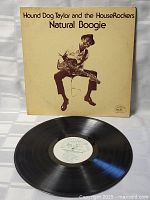 Photo of front album cover showing sepia-toned image of Hound Dog Taylor playing guitar with title text.