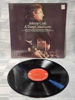 Front view of the Johnny Cash A Thing Called Love LP record and its album cover showing the cover art and the vinyl disc with red Columbia label.