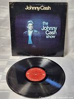 Front cover of The Johnny Cash Show vinyl LP showing vintage Johnny Cash photo and text on blue-black background with signs of wear.