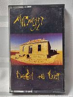 Front cover of the Midnight Oil Diesel and Dust cassette tape showing desert house artwork and album title.