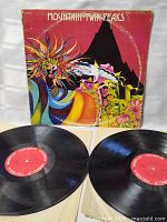 Photo showing front album cover of Mountain Twin Peaks with two vinyl records laid in front, displaying their red Columbia labels.