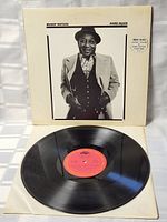 Front of vinyl record with cover propped open to show record label and cover photograph of Muddy Waters.