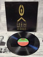 Front view of the LP vinyl record partially out of its cover, showing the black vinyl with center label and part of the cover artwork.