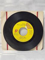 Front view of the vinyl record showing the 'Silver Train' label by The Rolling Stones on yellow background with original white sleeve.