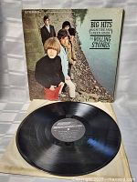 Photo showing the vintage album cover with band members standing on rocky ground, and the vinyl record in front with visible label details.