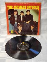 Vinyl LP disc of 'The Animals On Tour' with label visible, showing MGM logo and track details, placed in front of the album cover.