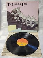 The vinyl record disc displayed outside the cover, label visible with album title and band name.