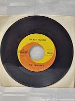 Front view of black 45 RPM vinyl record with a vibrant yellow and orange Capitol Records label for the song 'I'm Not Talking' by The Yardbirds.
