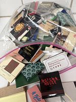 Plastic bags holding 100 vintage matchbooks with various branding and designs, visibly new and unused.