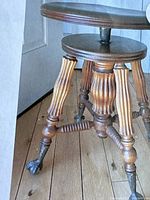 Close-up of turned wood leg with metal ball and claw foot showing detailed carvings