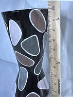 Vase measuring with a ruler showing about 10 inches tall, close-up on pattern and shape