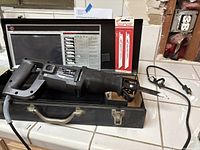 Black & Decker 3108 two speed reciprocating cut saw in original metal case with original instruction chart and blade packs inside case.