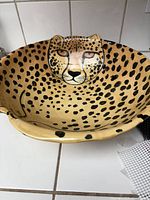 Top view of the large round ceramic bowl showing the hand-painted cheetah face and spotted pattern inside the bowl.