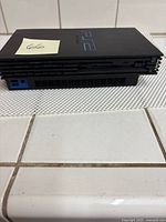 Side view of the Sony PS2 2000 console showing its slim design and vent openings.