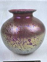 Front view of the cranberry iridescent glass vase showing textured iridescent pattern and flared neck.