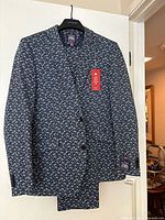 Full front view of men's blue floral slim fit suit jacket on hanger showing front closure and pattern detail.