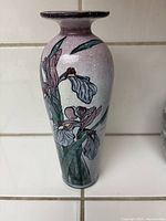 Front and side view of tall ceramic vase with purple iris flower painting on speckled light purple background.