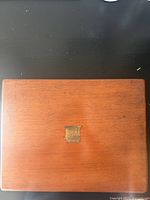 Closed wooden box with brass plate on lid, polished brown finish