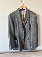 Front view of grey cashmere Hugo Boss suit jacket hanging on wooden hanger.